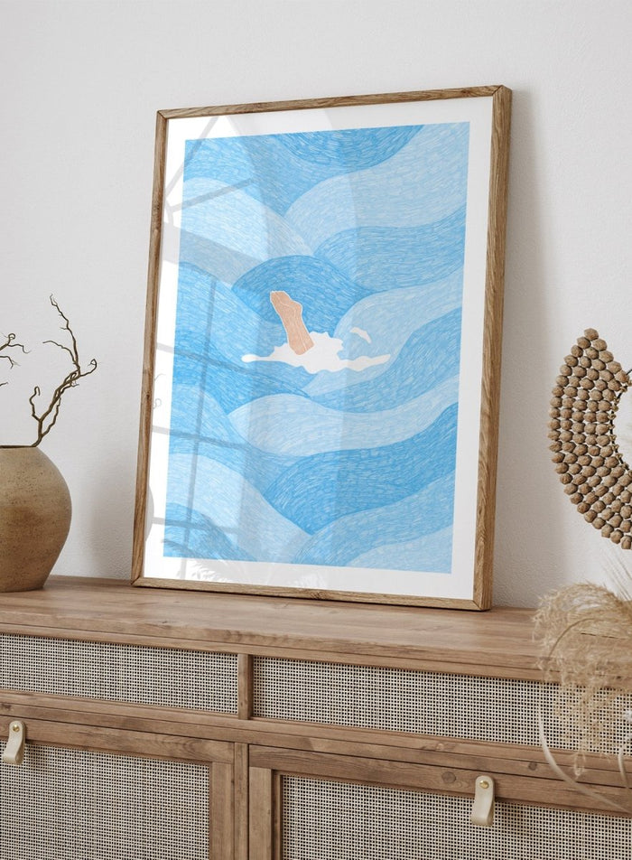 Illustration of a person swimming in blue water with a white border. Hand Reaching Blue Ocean by Rio Soléy is a modern coastal art print featuring swirling blue waves, minimalist illustration, playful design, and contemporary seaside charm.