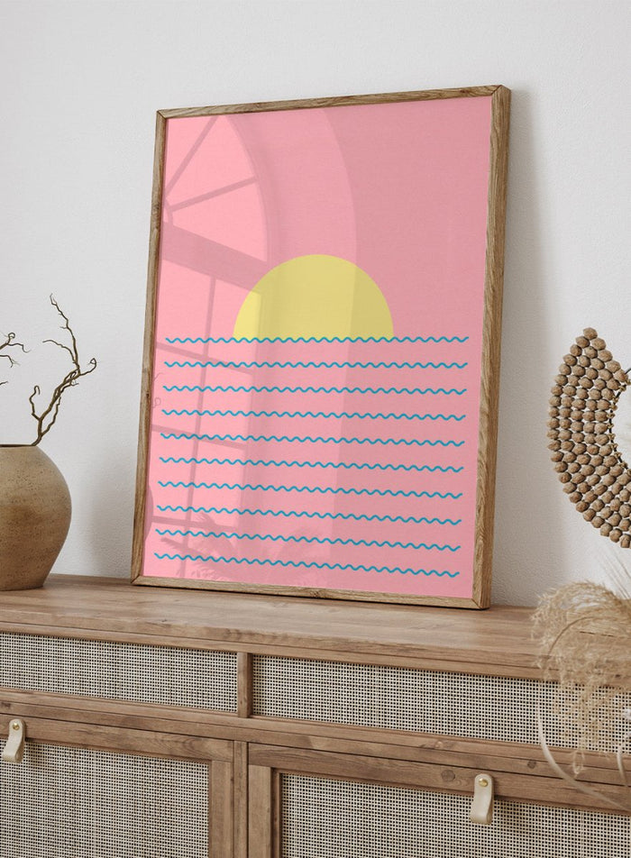Simplified illustration of a sunset over water with blue waves on a pink background. Every Day the Sun Rises by Rosi Feist is a minimalist sun and waves art print with pink sky. Officially licensed modern poster with framing.