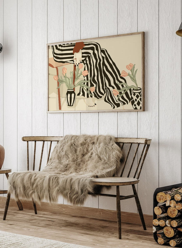 Artistic depiction of a person with striped pants sitting on a chair with floral arrangements. Tulips By My Feet by Sannel Larson is a modern minimalist art print with woman in striped pants and soft tulips. Officially licensed wall poster with framing.