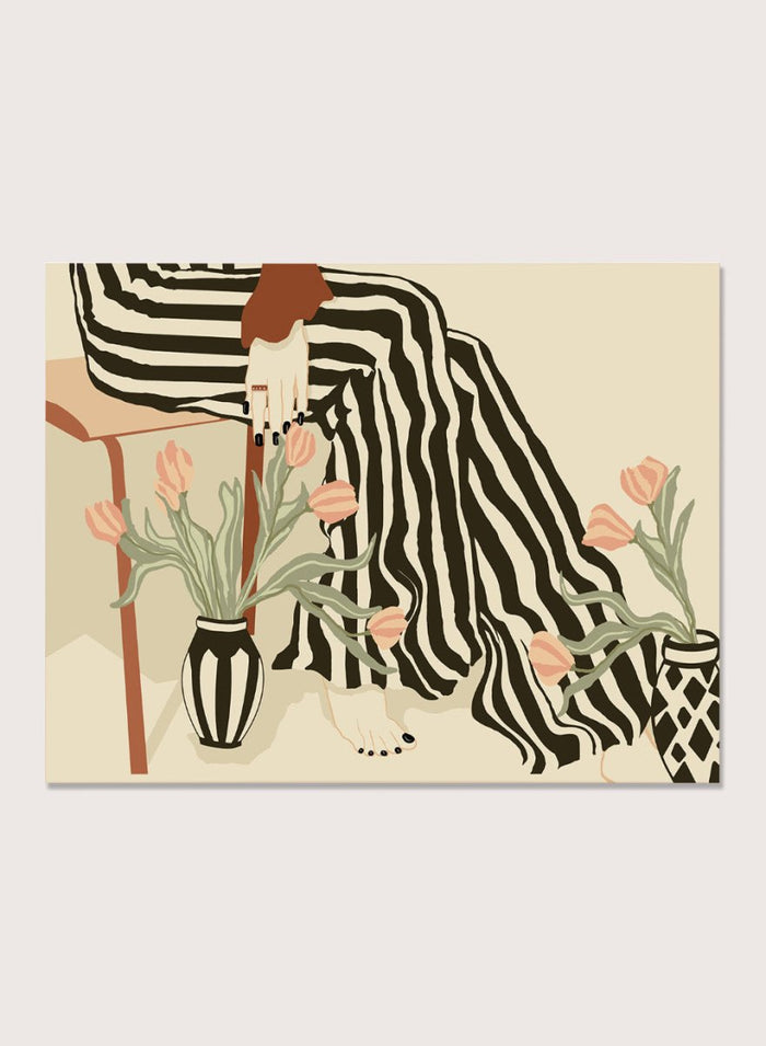 Artistic depiction of a person with striped pants sitting on a chair with floral arrangements. Tulips By My Feet by Sannel Larson is a modern minimalist art print with woman in striped pants and soft tulips. Officially licensed wall poster with framing.
