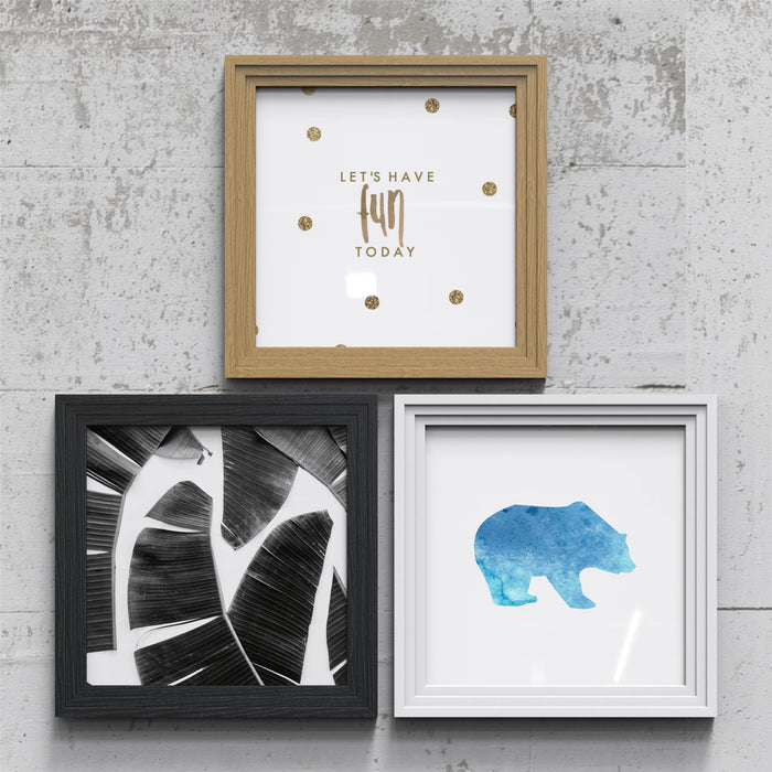 Oak picture and poster frame showcasing three different designs against a concrete wall.